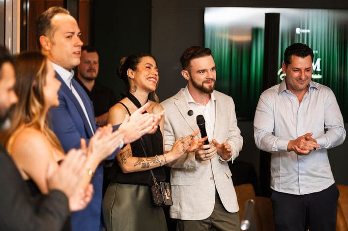 Membros do Club M aplaudindo em um evento